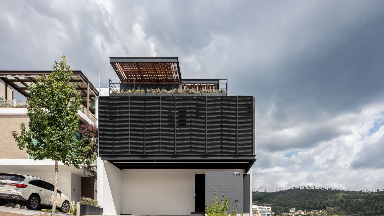 Casa AJ — volumen negro sobre el valle